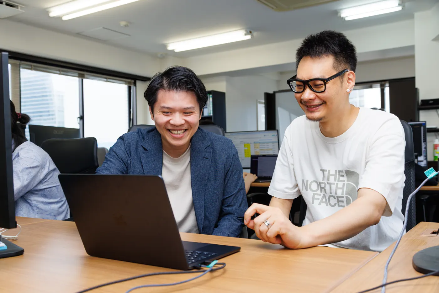 ノートPCを前に笑顔で話すメンバー